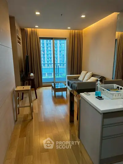 Modern living room with wooden flooring and large windows offering city view.