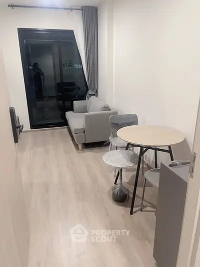 Modern living room with sleek furniture and large window for natural light.