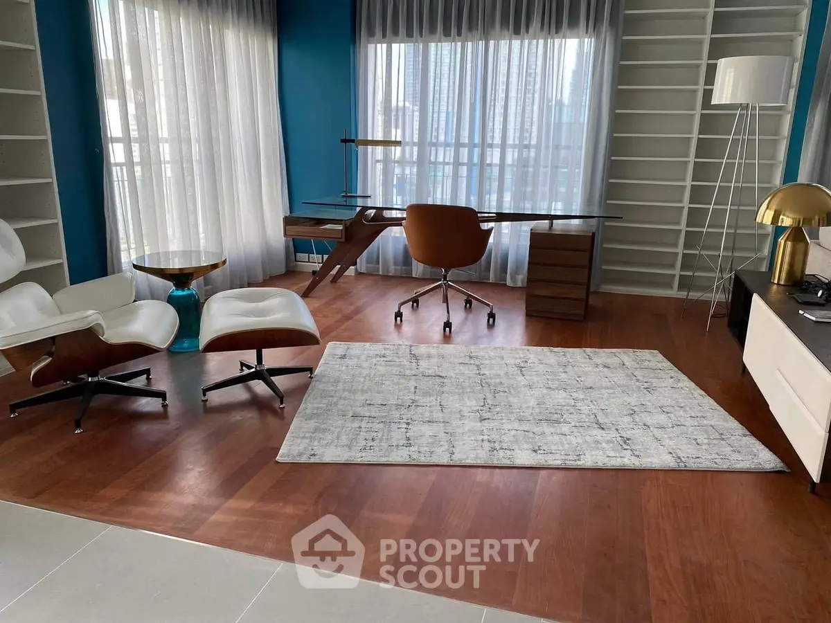 Modern study room with elegant desk and comfortable seating, featuring floor-to-ceiling windows and stylish decor.