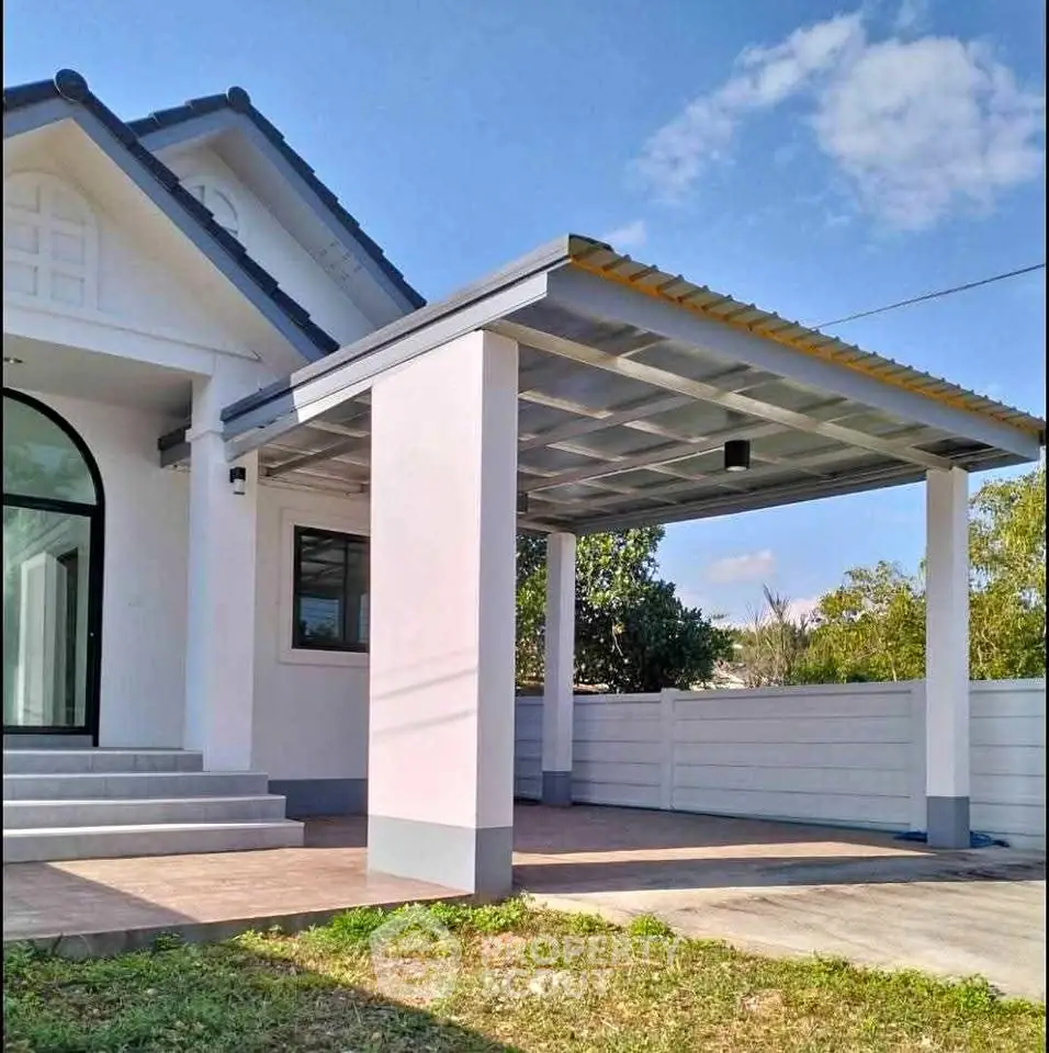 Charming modern house with covered carport and lush greenery, perfect for family living.