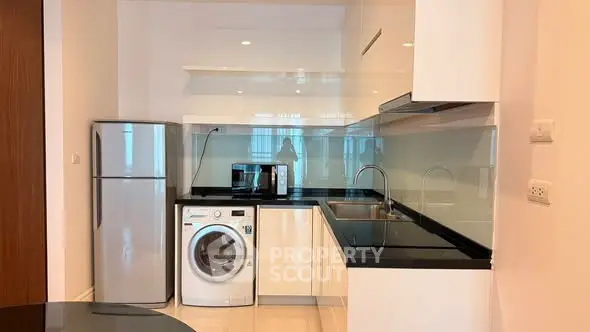Modern kitchen with sleek appliances and glossy cabinetry in a stylish apartment.