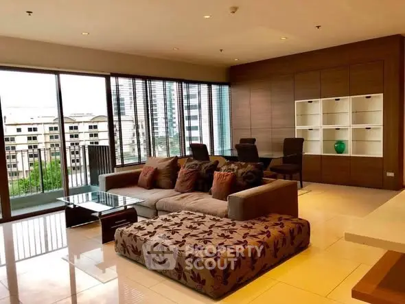 Spacious modern living room with large windows and stylish furniture in urban apartment.