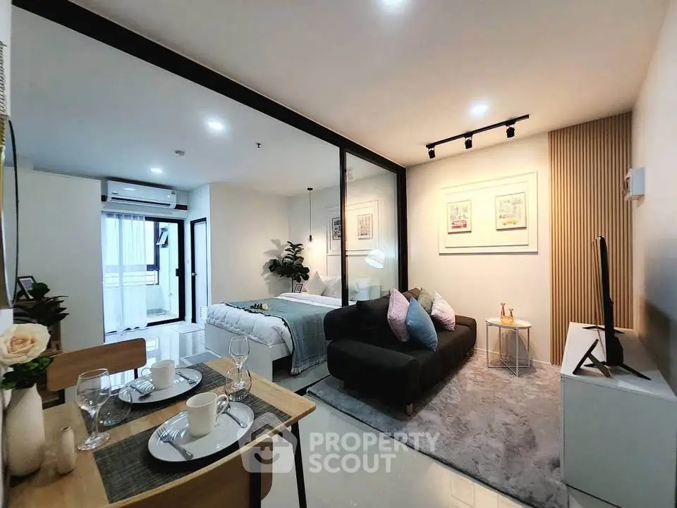 Modern open-plan living room and bedroom with stylish decor and natural light