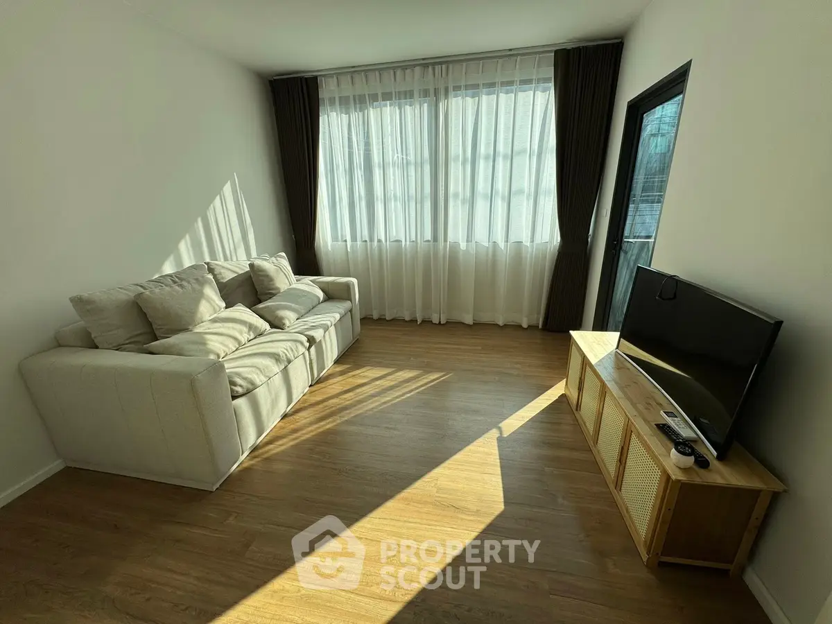 Bright living room with cozy sofa and large window, perfect for relaxation.
