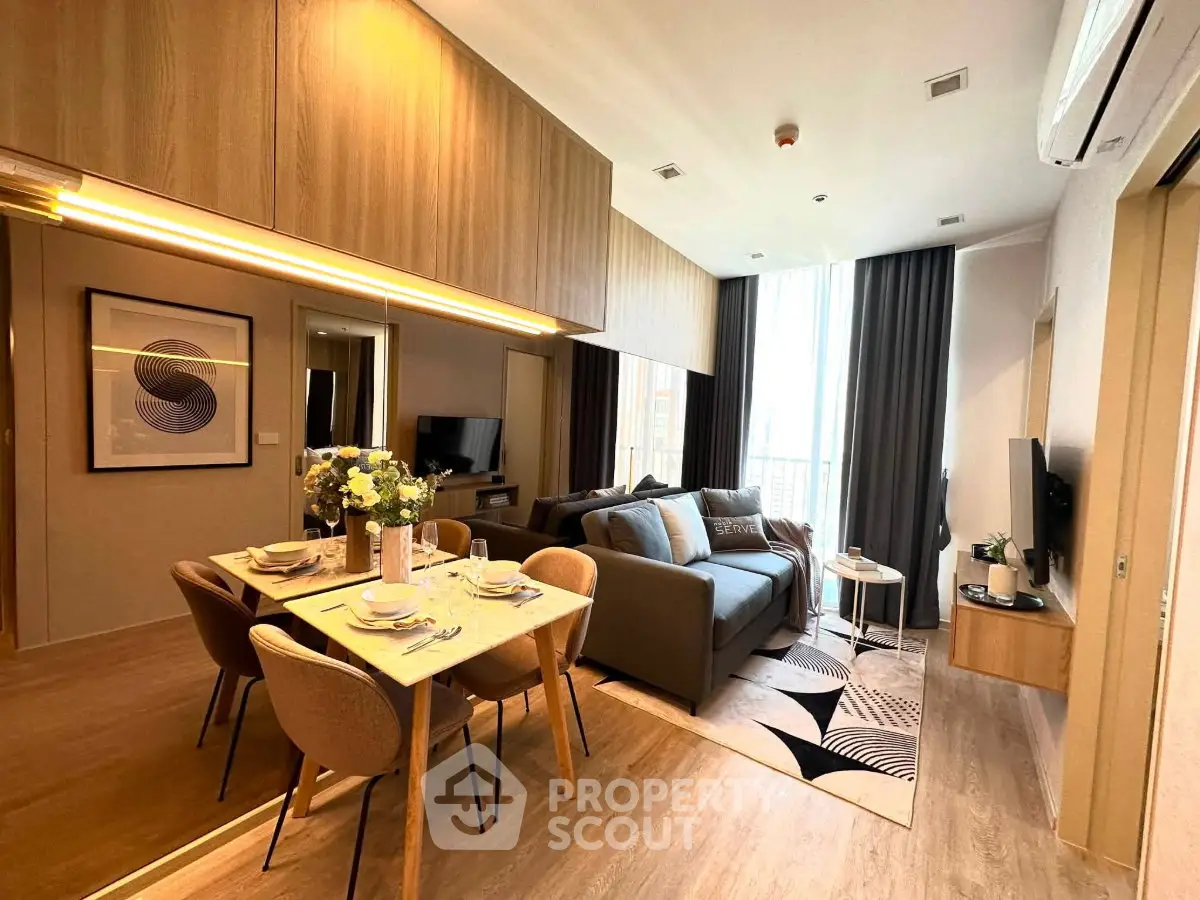 Modern open-plan living room with stylish dining area and cozy seating, featuring elegant decor and natural light.
