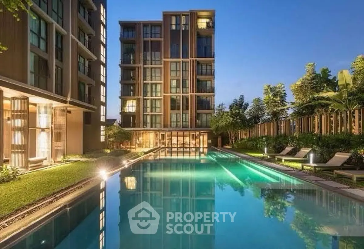 Luxurious apartment complex with stunning pool and modern architecture at dusk.