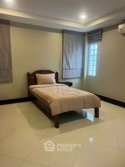 Spacious bedroom with single bed and modern decor, ideal for cozy living.