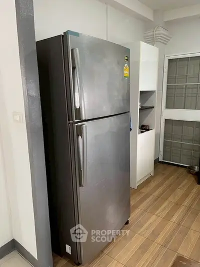 Modern kitchen with stainless steel fridge and wooden flooring
