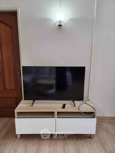 Modern living room with sleek TV stand and flat-screen TV, perfect for entertainment.