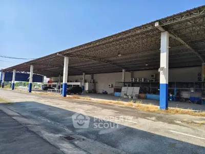 Spacious industrial warehouse with ample parking and high ceilings, ideal for logistics or manufacturing.