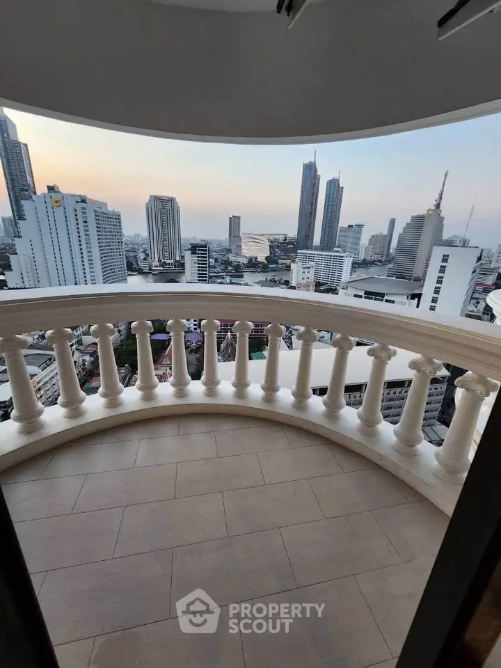 Stunning cityscape view from a curved balcony in a high-rise apartment, showcasing urban skyline at dusk.