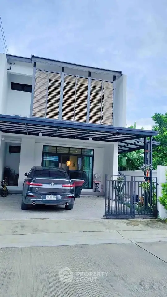 Modern two-story house with carport and sleek exterior design.