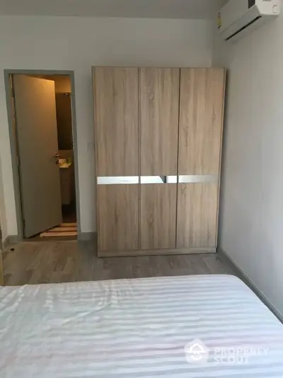 Modern bedroom with wooden wardrobe and air conditioning