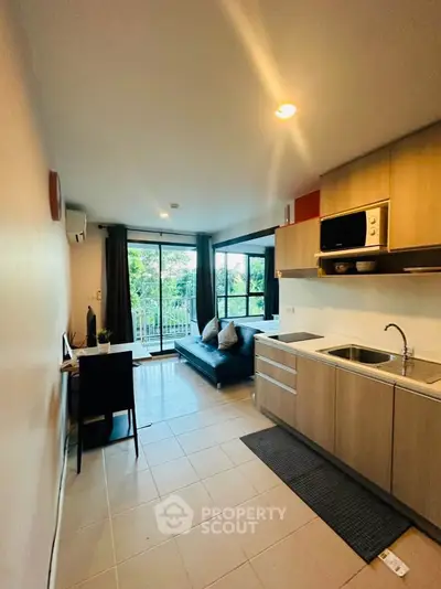 Modern open-layout kitchen and living area with balcony view