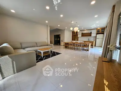 Spacious open-plan living room with modern kitchen and elegant dining area, perfect for family gatherings.