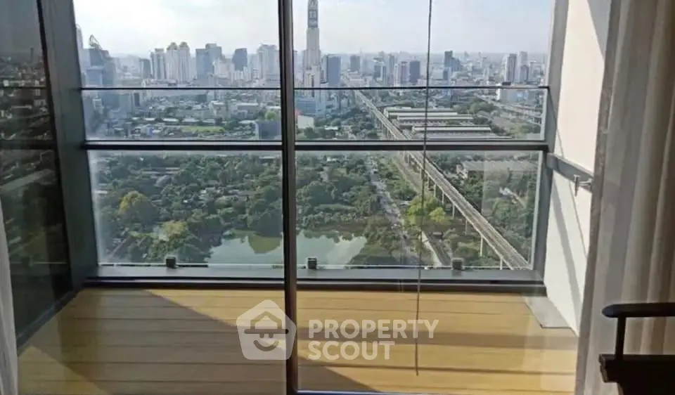 Stunning high-rise balcony view overlooking city skyline and lush greenery, perfect for urban living.