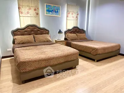 Spacious bedroom with two elegant beds and stylish decor, perfect for comfort and relaxation.