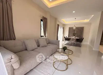 Luxurious living room with plush sofa and elegant dining area in modern open layout.