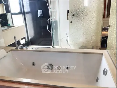 Luxurious bathroom with modern bathtub and elegant shower area in a high-end apartment.