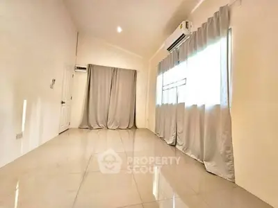 Spacious empty room with large windows and air conditioning, perfect for customization.