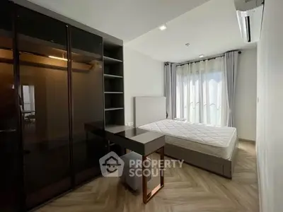 Modern bedroom with sleek wardrobe and large window in a stylish apartment