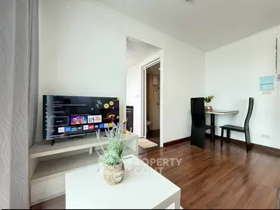 Modern living room with sleek TV setup and stylish dining area, perfect for cozy urban living.