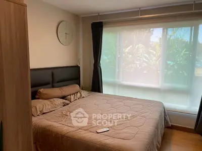 Cozy bedroom with large window and modern decor, perfect for relaxation and comfort.