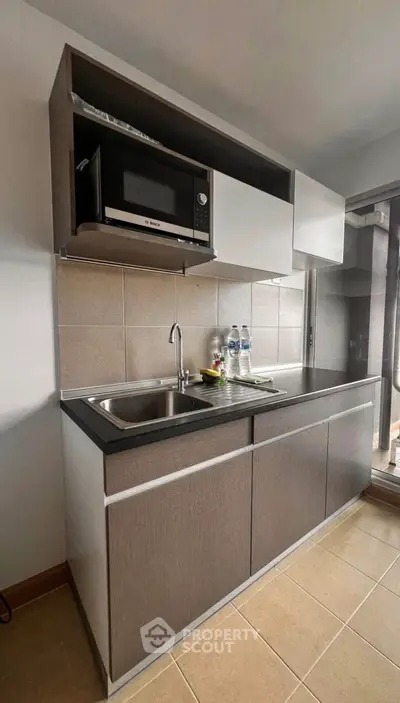 Modern kitchen with sleek cabinetry and built-in microwave, perfect for urban living.