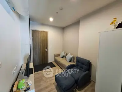 Cozy living room with modern furniture and neutral decor in a compact apartment.