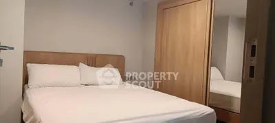 Cozy bedroom with wooden wardrobe and comfortable bed in modern apartment.