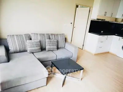 Modern living room with stylish gray sofa and sleek kitchen area