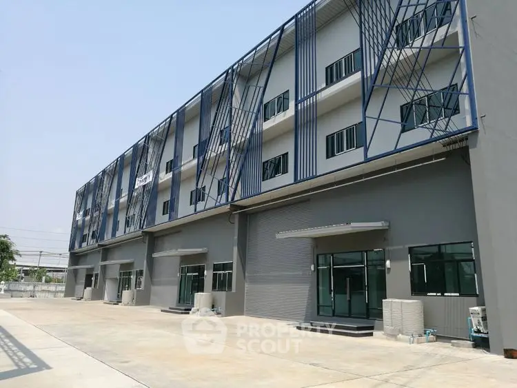 Modern commercial building with sleek design and spacious parking area