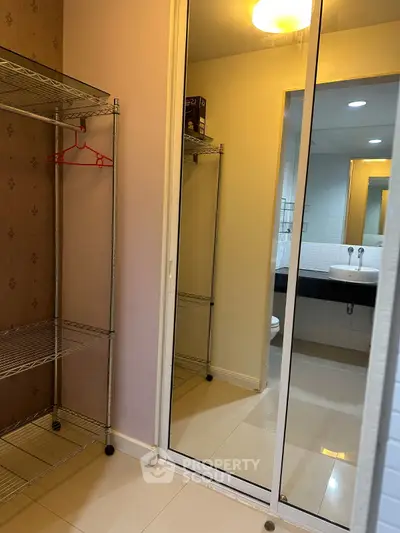 Spacious bathroom with mirrored closet and modern fixtures, perfect for stylish living.