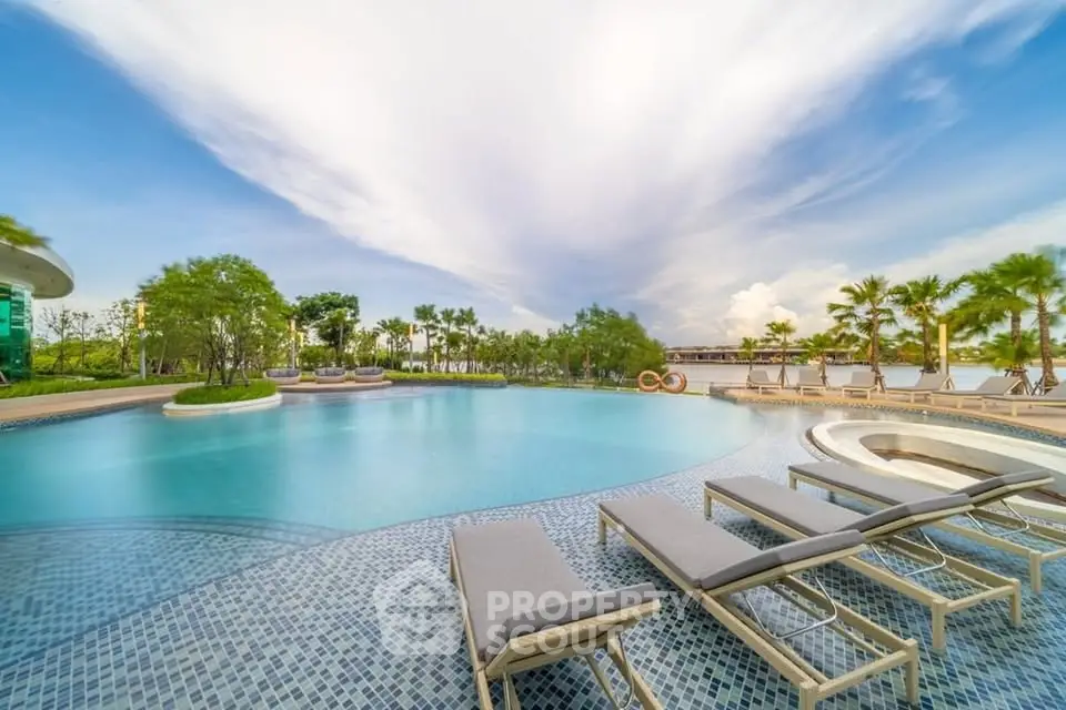 Luxurious outdoor pool area with sun loungers and stunning sky view, perfect for relaxation and leisure.