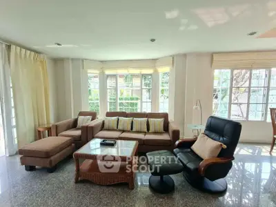 Spacious living room with cozy seating and large windows offering natural light.