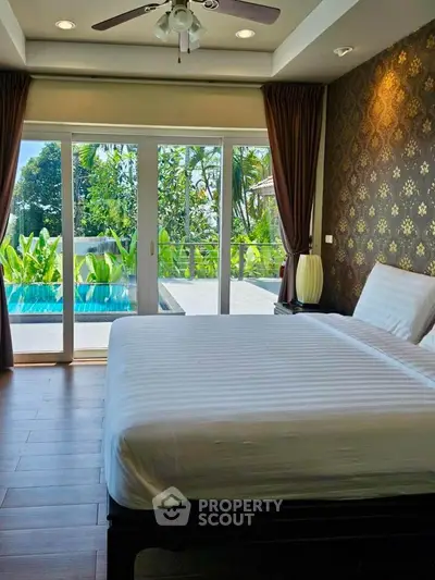 Luxurious bedroom with pool view and elegant decor in tropical setting