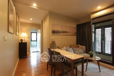 Cozy living room with modern decor and natural light, featuring a comfortable sofa and dining area.