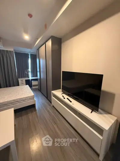 Modern bedroom with sleek design, featuring a large wardrobe and flat-screen TV, perfect for urban living.