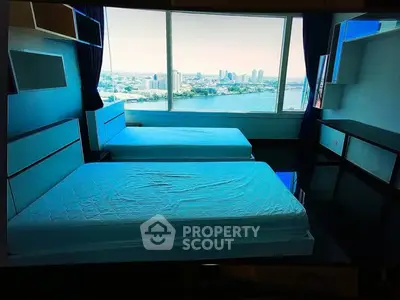 Spacious bedroom with twin beds and stunning city skyline view through large windows.