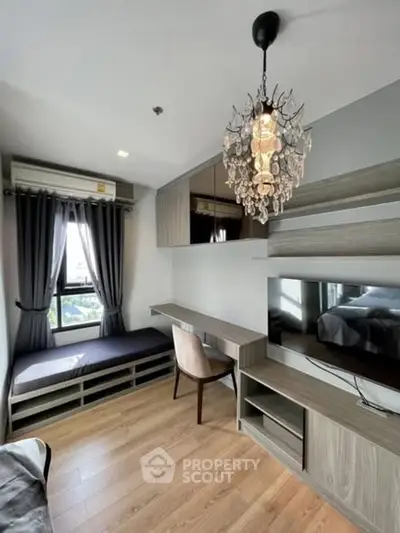 Modern study room with elegant chandelier and built-in desk in stylish apartment.