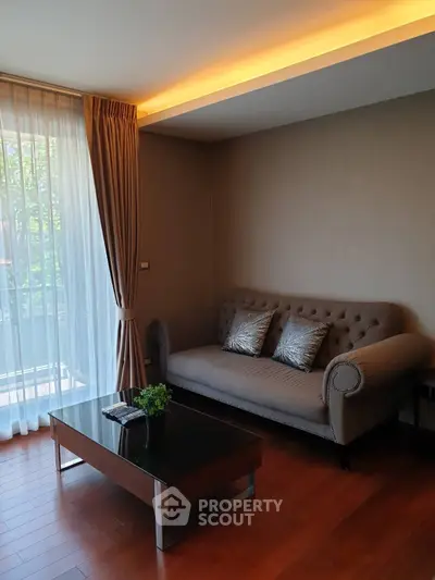 Elegant living room with modern sofa, stylish coffee table, and large window with natural light.