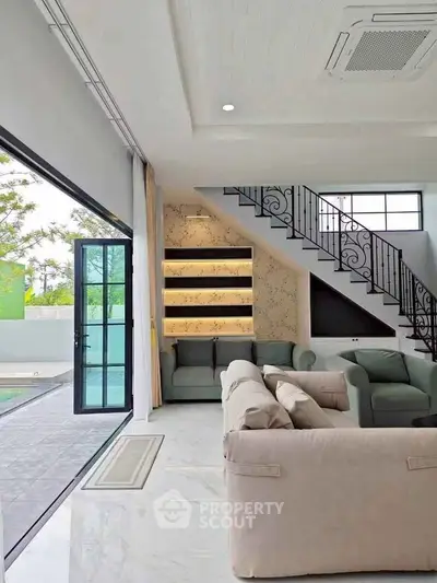Spacious modern living room with pool view and elegant staircase