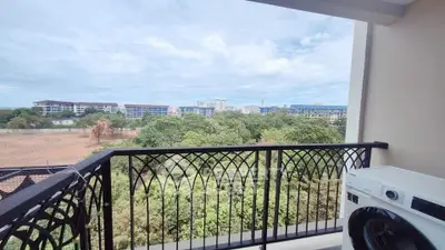 Spacious balcony with scenic view and washing machine, perfect for relaxation and convenience.