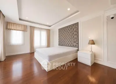 Spacious modern bedroom with elegant hardwood floors and stylish decor