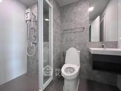 Modern bathroom with sleek shower and contemporary fixtures in stylish gray tones.