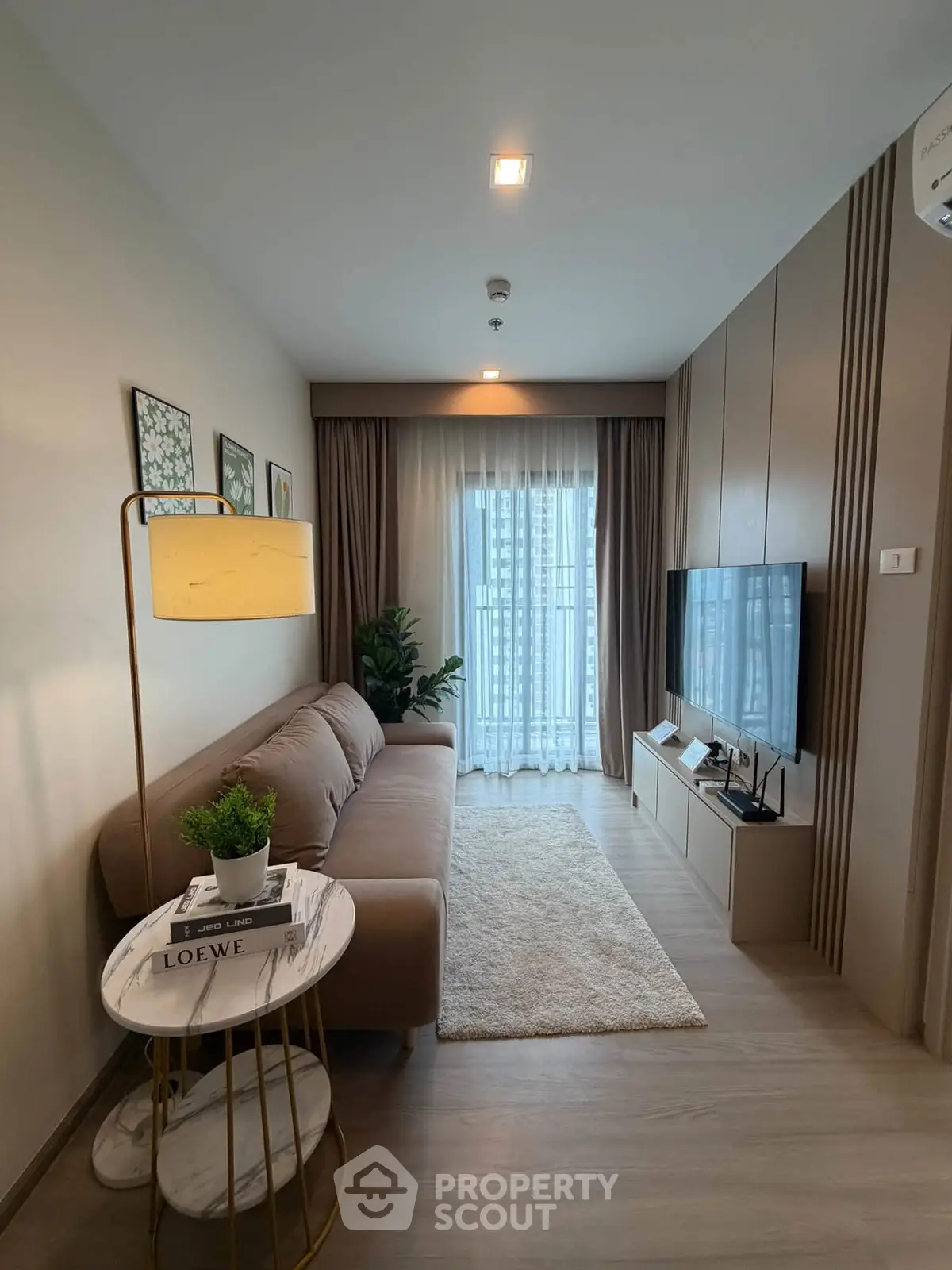 Modern living room with cozy sofa, stylish decor, and large window for natural light.