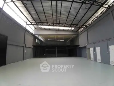 Spacious industrial warehouse with high ceilings and modern design, perfect for storage or business operations.