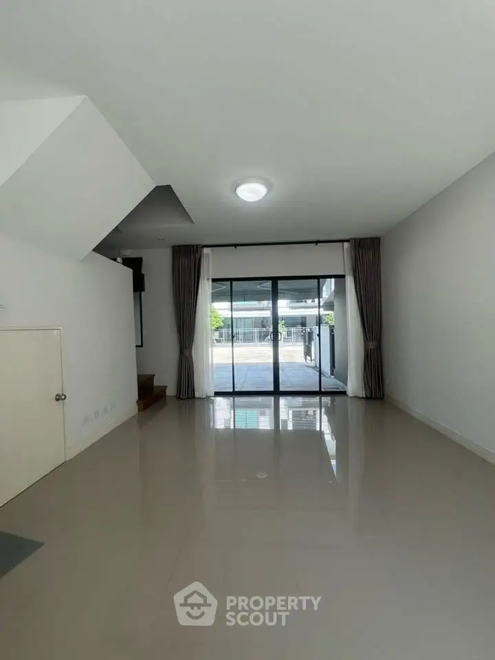 Spacious modern living room with large windows and sleek flooring