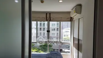 Cozy bedroom with large window and air conditioning in modern apartment