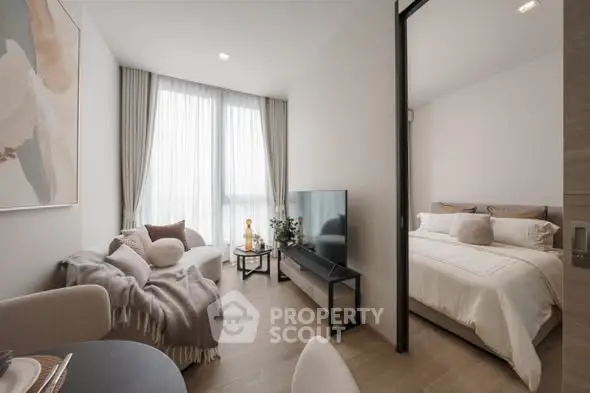 Modern open-plan living room and bedroom with stylish decor and natural light